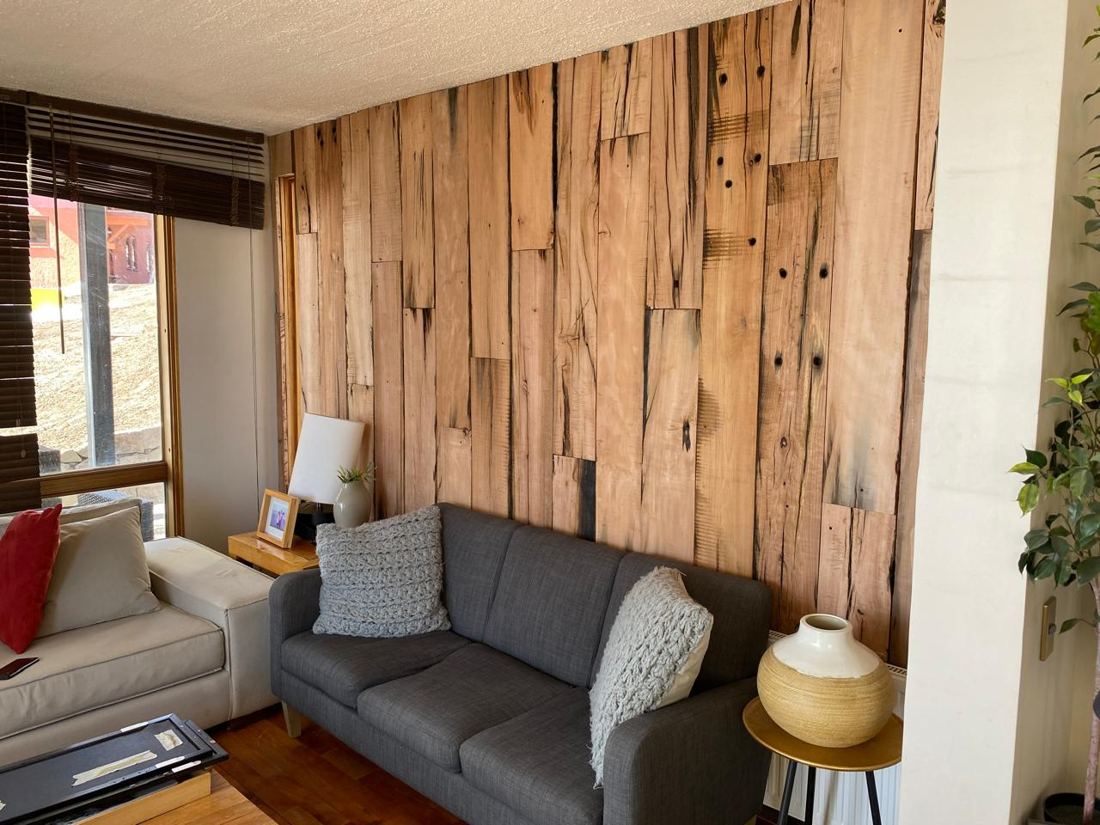 Living de departamento en La Parva con muro revestido en durmientes de madera