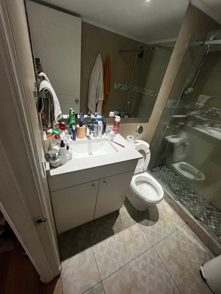 Baño antes de la remodelación, con mueble blanco y cerámica antigua