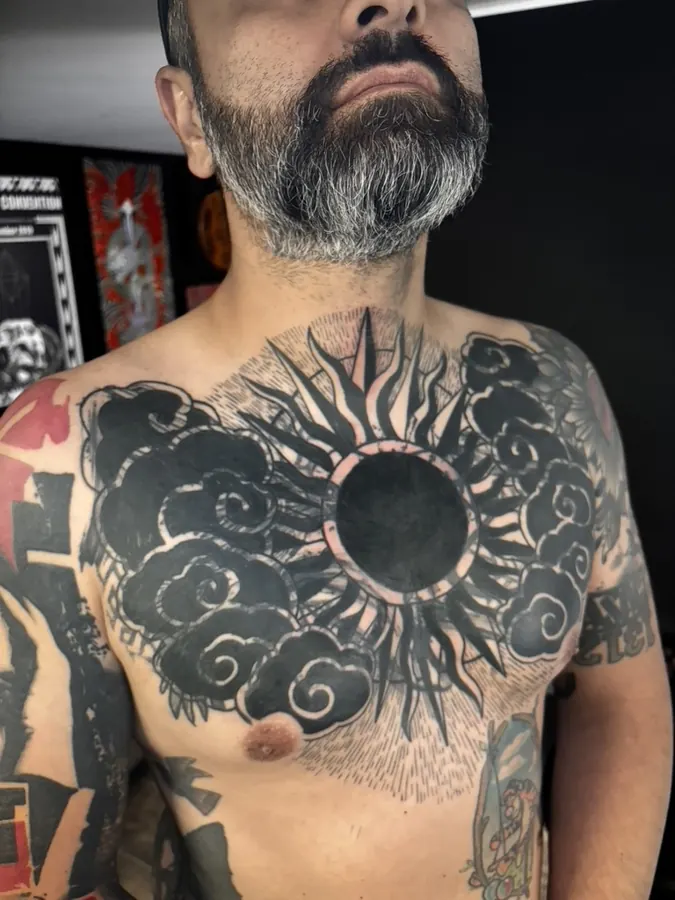 Black sun and clouds chest piece tattoo by Orne
