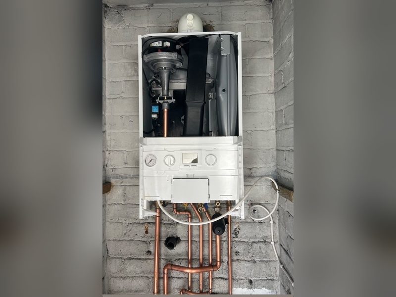 Combi boiler being installed with the front cover off