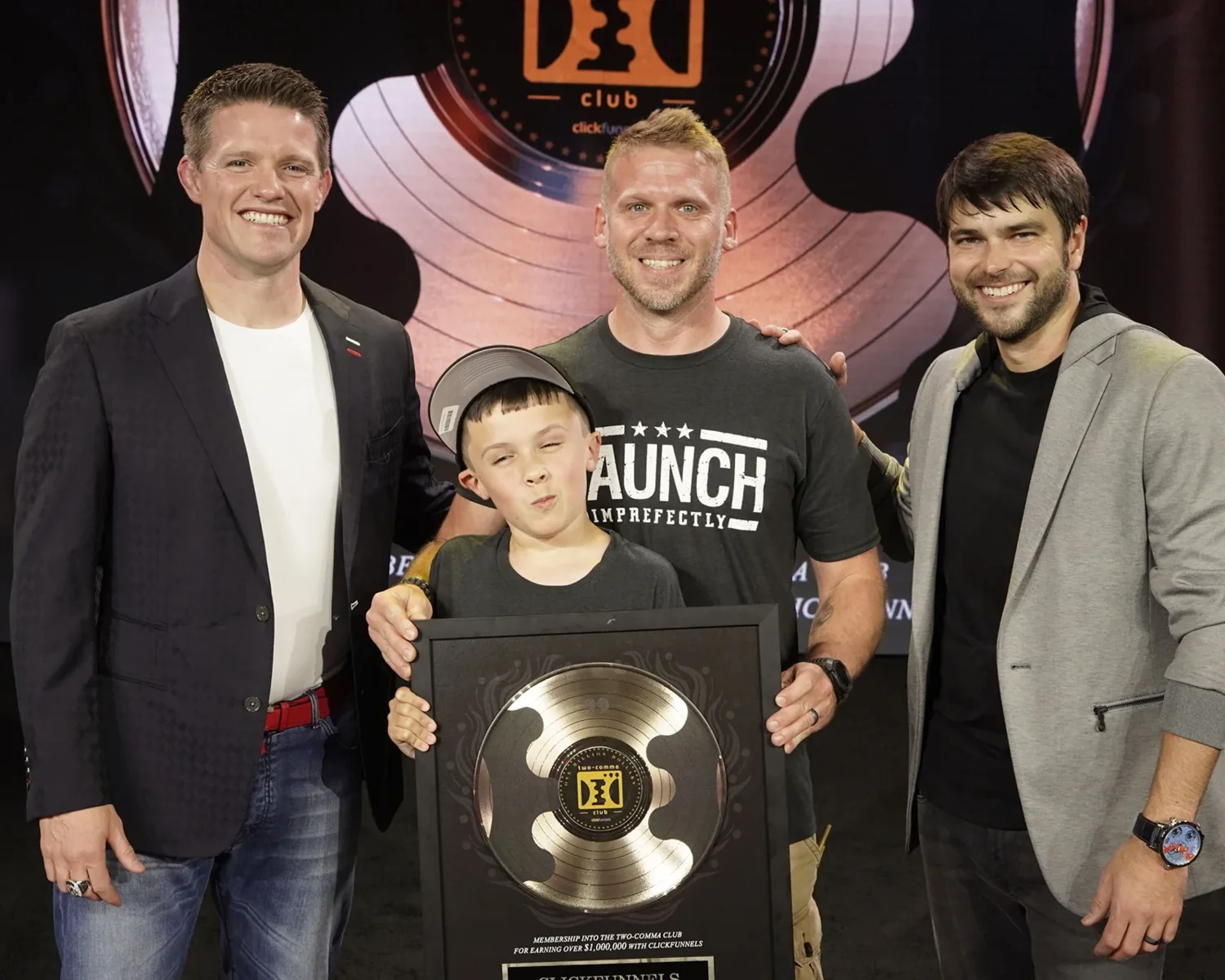 Shawn Myers, at center behind his son, celebrating his ClickFunnels Two Comma Club award.