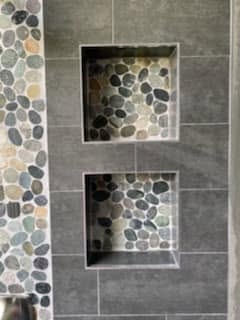 Dark shower wall with pebble niches