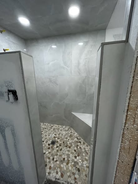 Walk-in shower marble walls and pebble floor