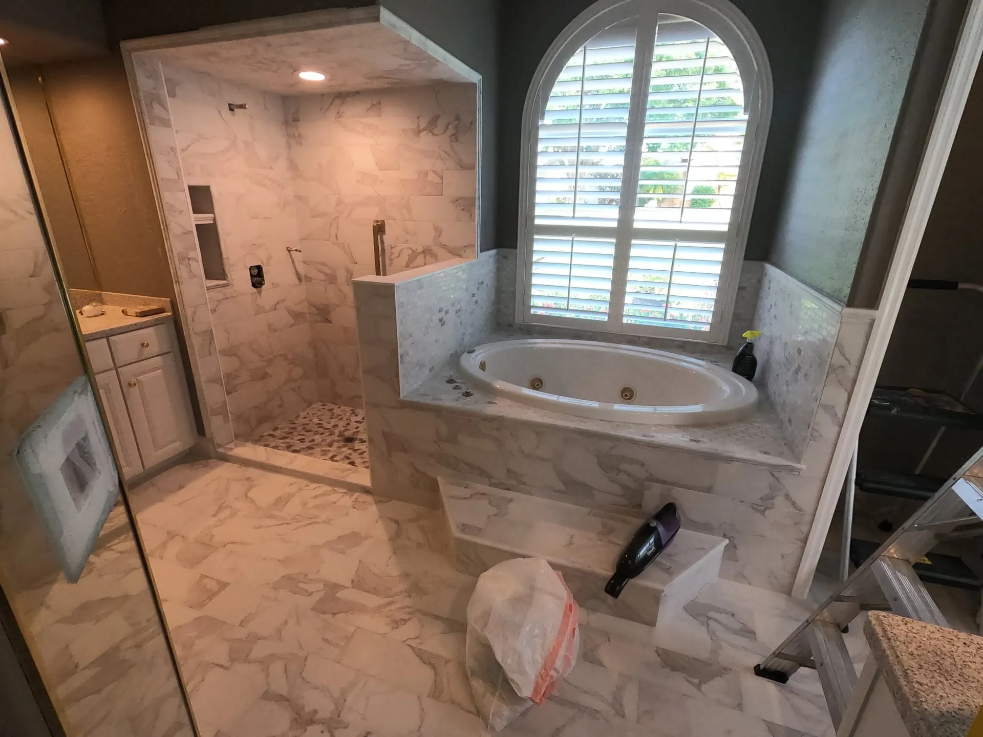 Walk-in shower with jetted tub and marble floors