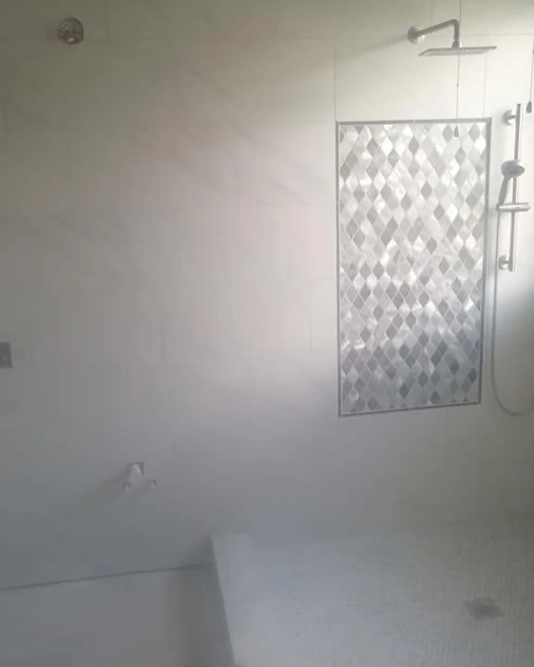 Marble walk-in shower with mosaic accent panel