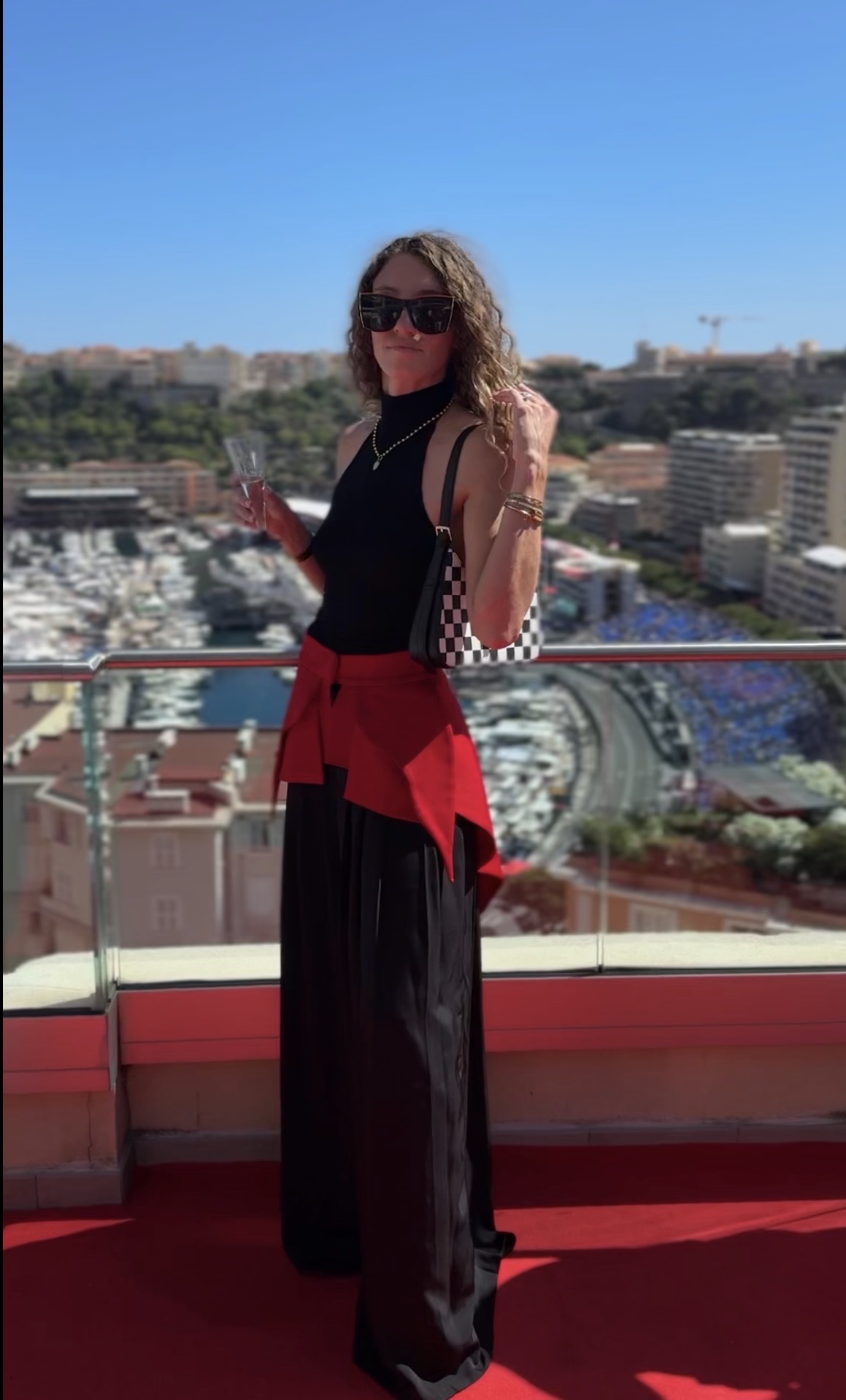 Client wearing a black look with a red waist detail