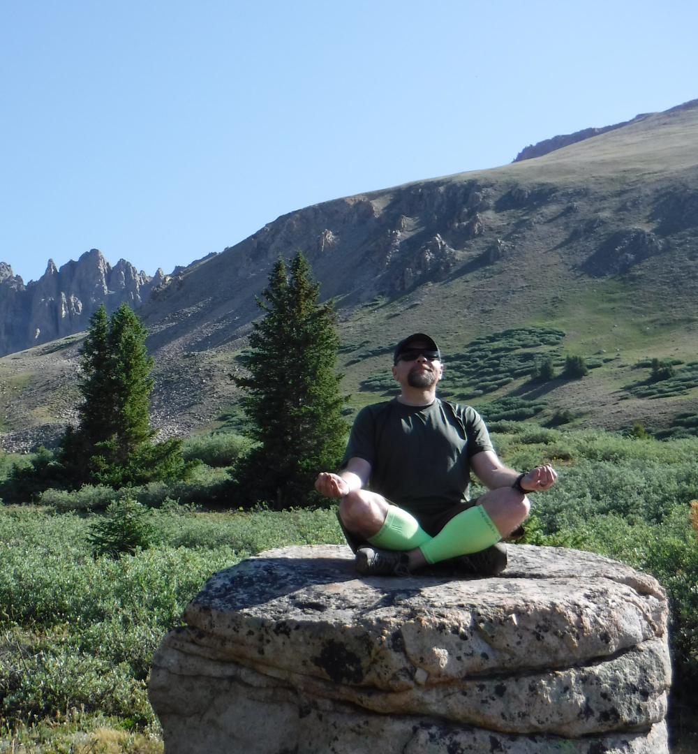 Andy meditating on a boulder in an alpine meadow — Colorado Rockies