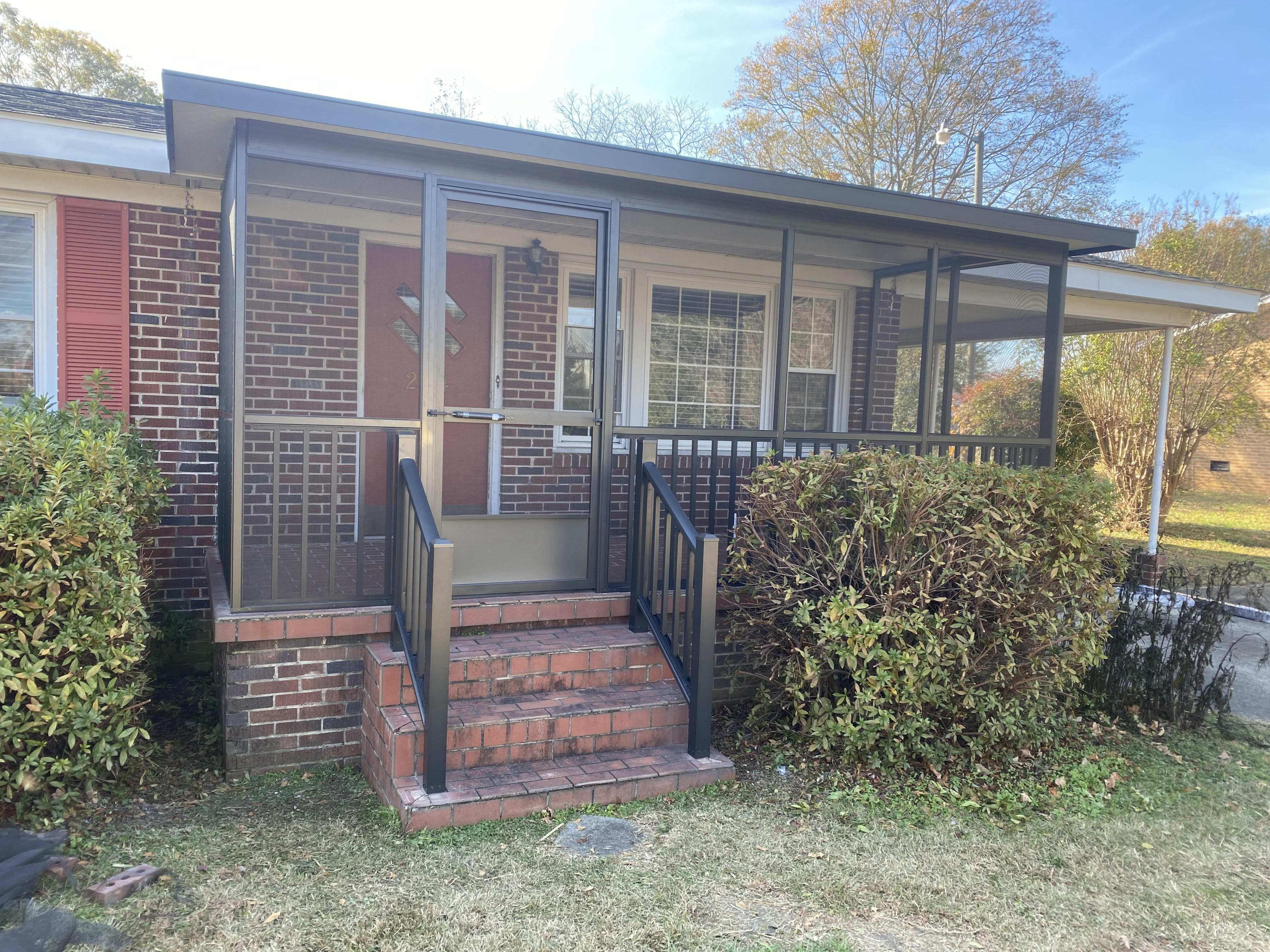 Finished screened porch with bronze-tone framing on a brick Berea home