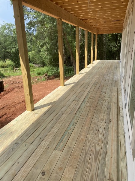 Large Ryan porch under construction with posts and exposed roof framing