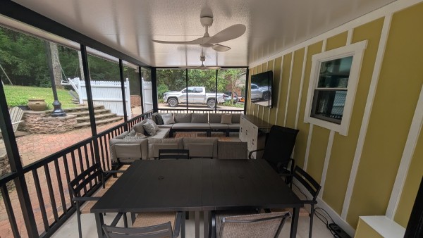 Finished screened outdoor room with seating, dining area, and television in Anderson, South Carolina