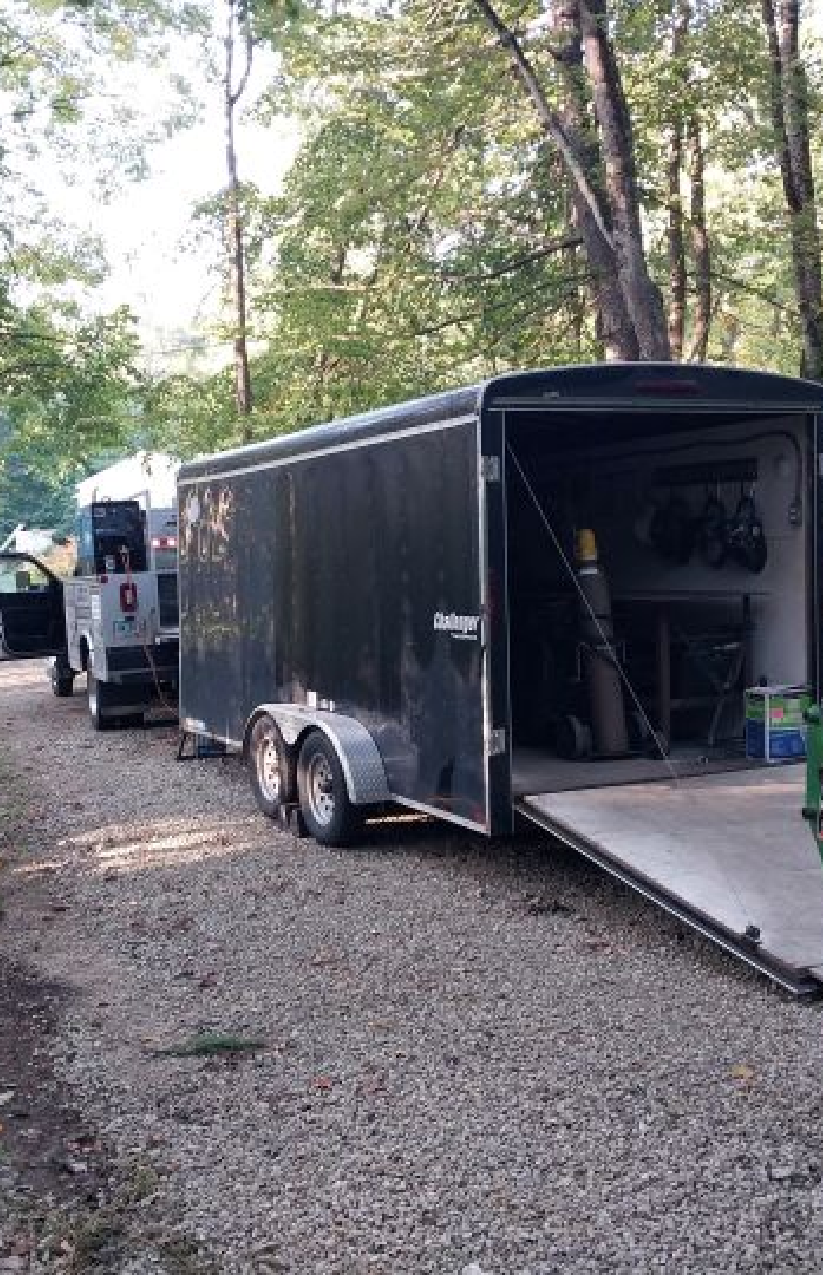 Mobile welding trailer setup in wooded area by Warrior Welding LLC, offering on-site welding services in NH, ME, and MA