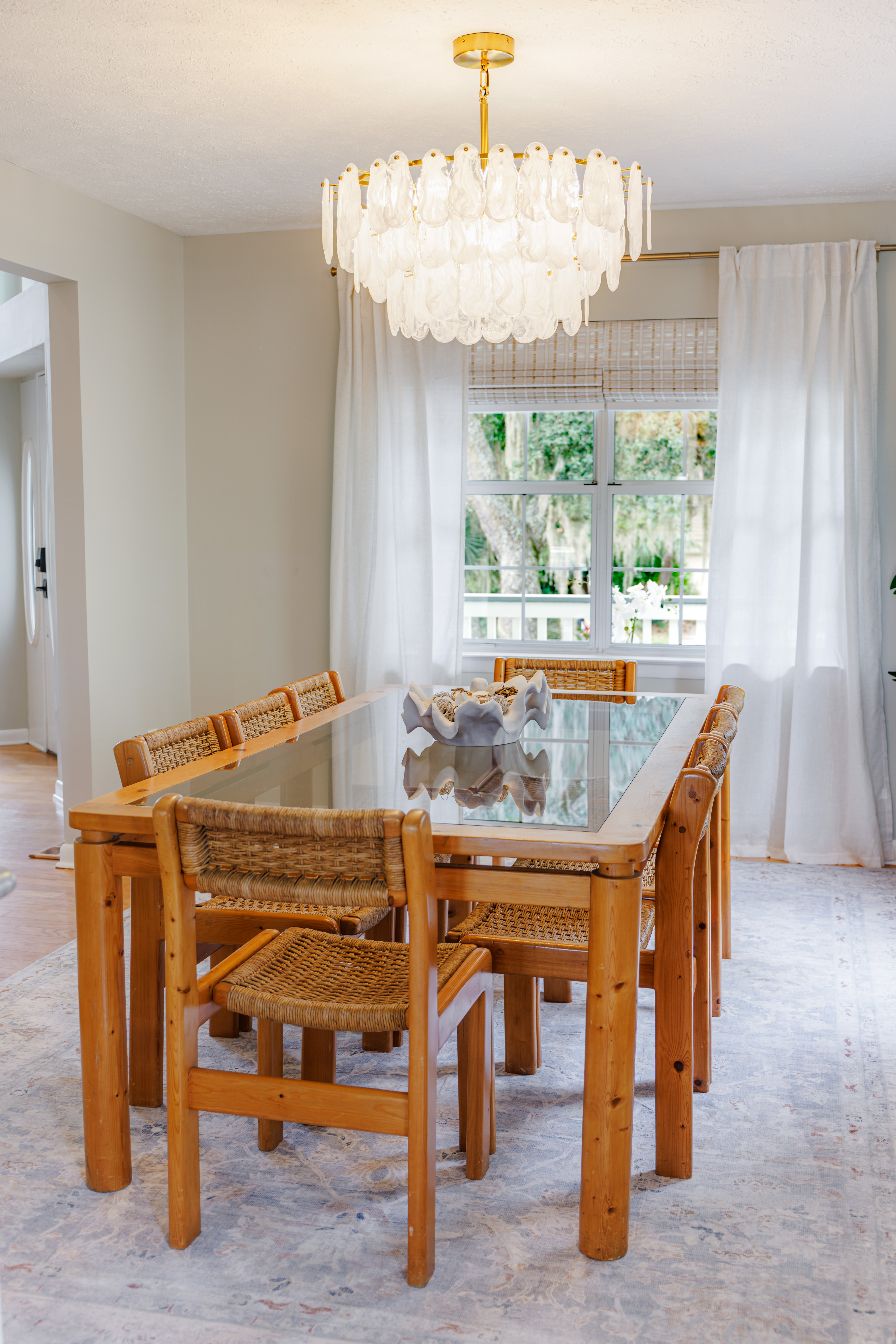 Residential dining room styled with ceramics, linen runner and muted greenery