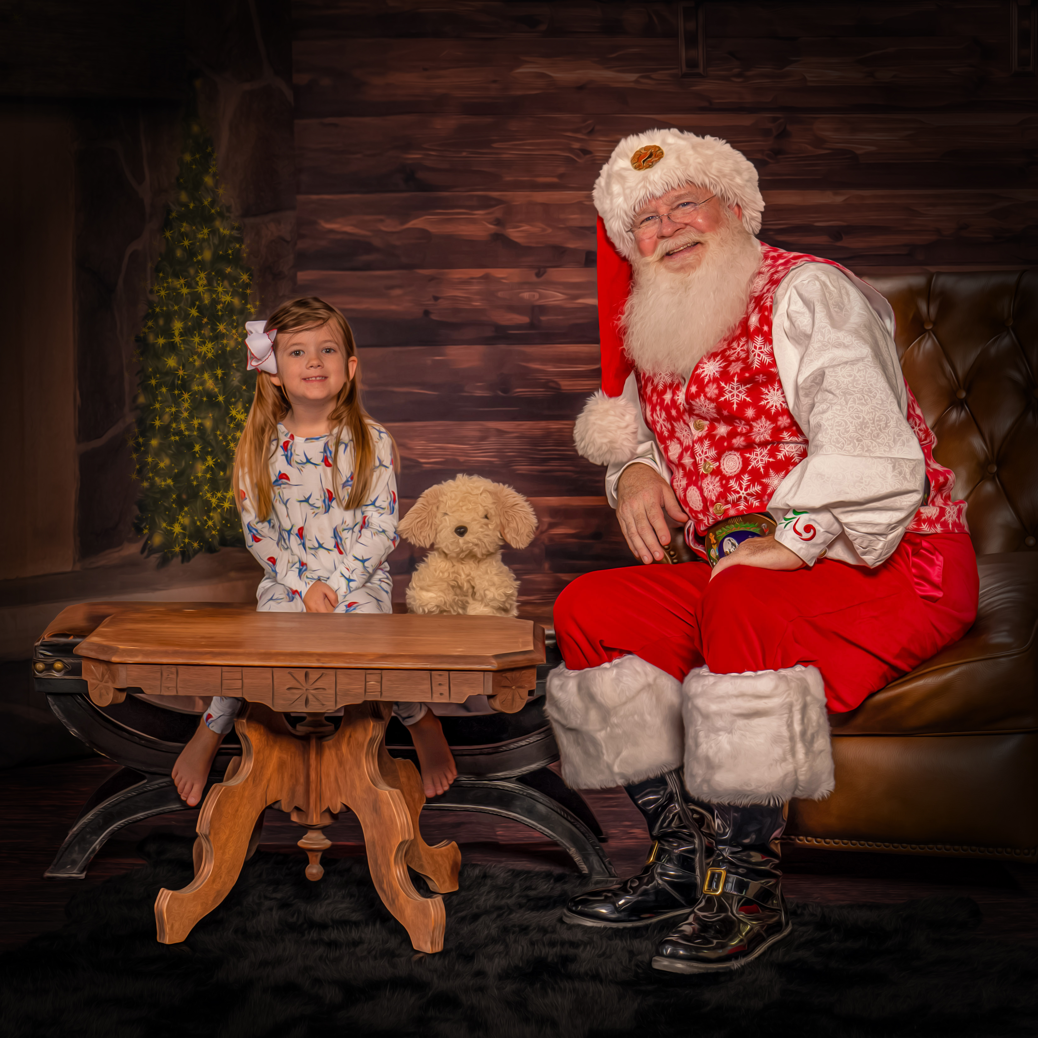 Santa George smiling with a child and her stuffed dog during The Magic of Santa experience