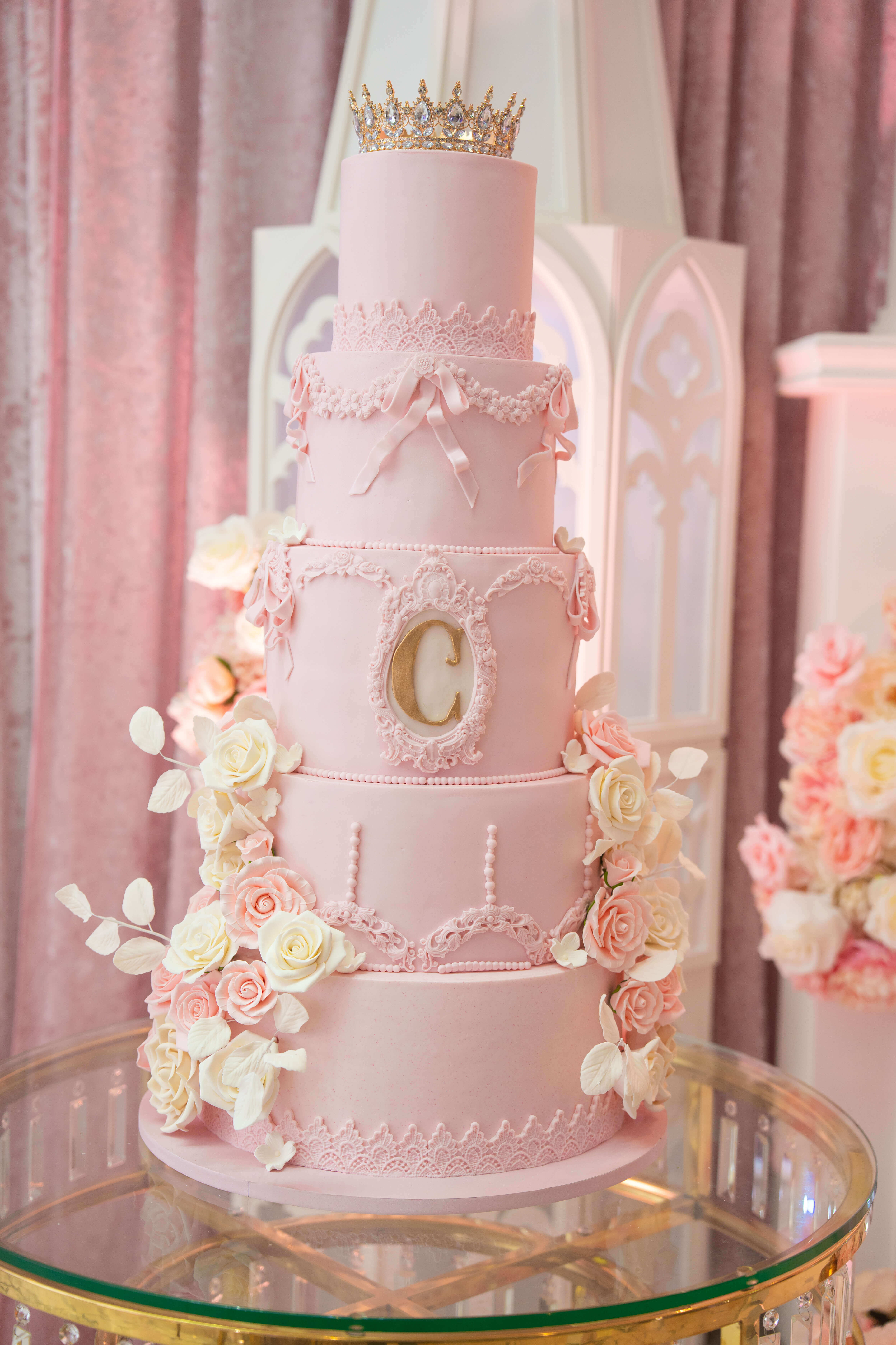Pastel de Quinceañera rosa de cinco pisos con corona y flores