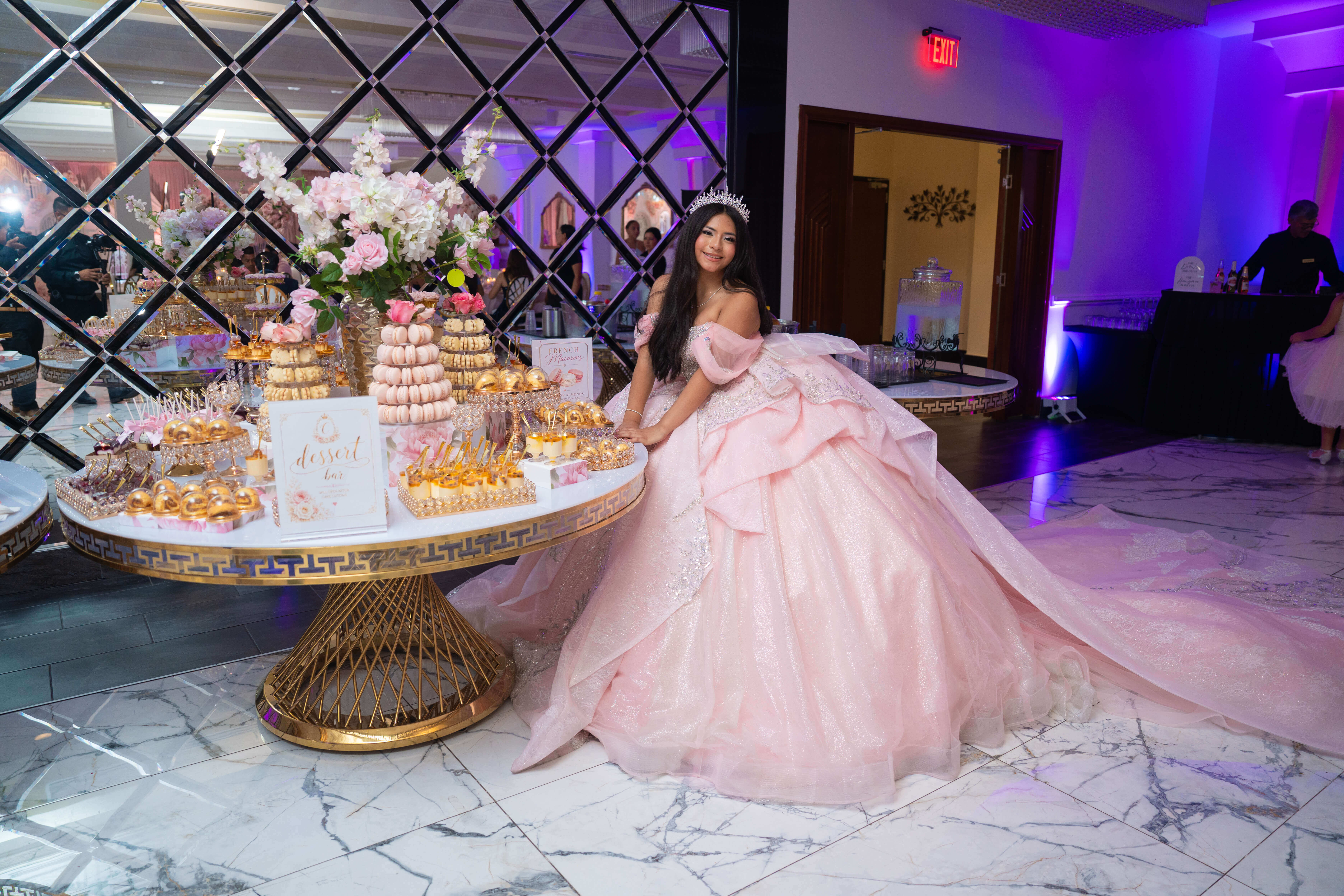 Quinceañera junto a la mesa de postres decorada
