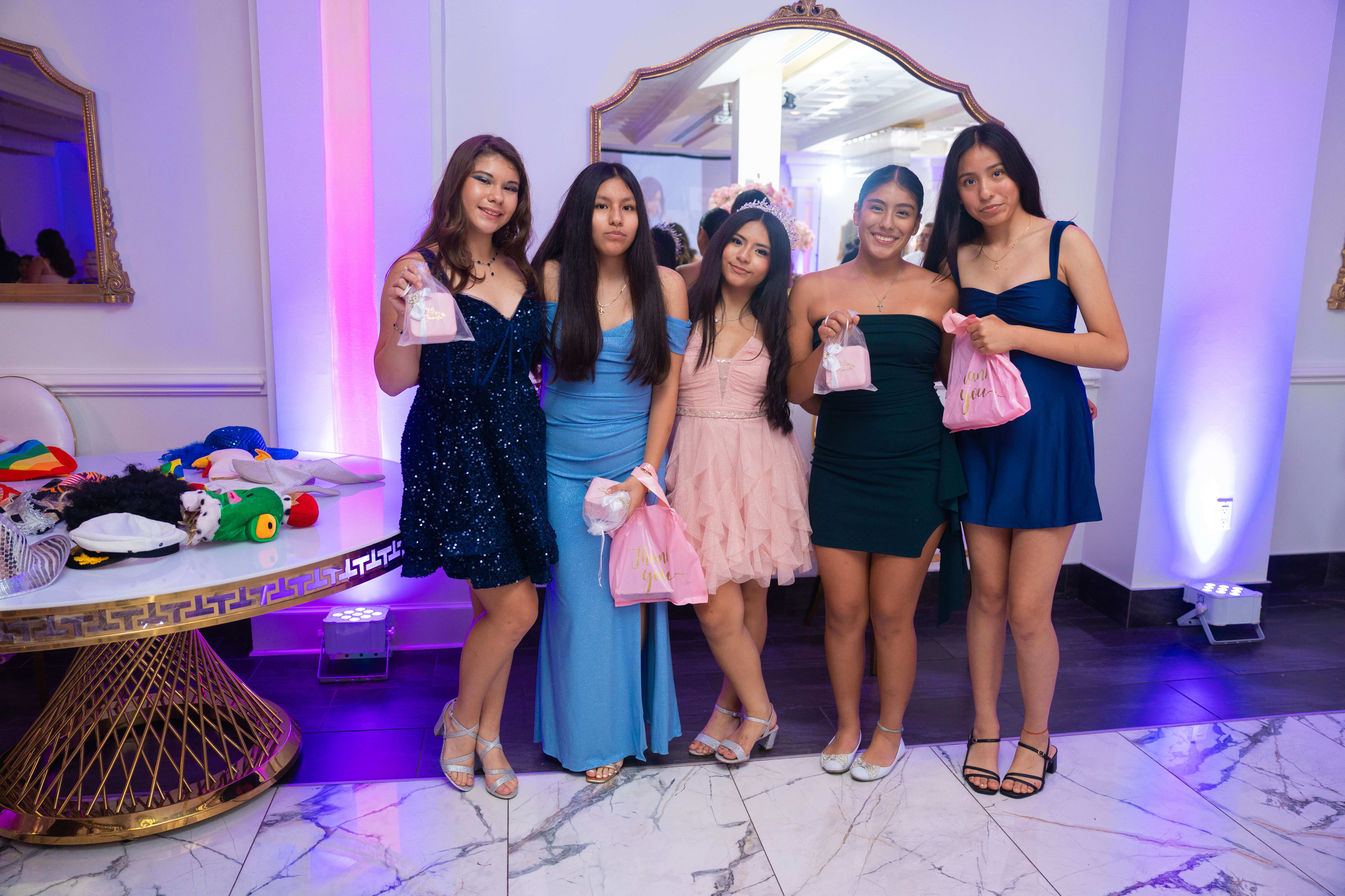 Quinceañera posando con sus amigas en la fiesta
