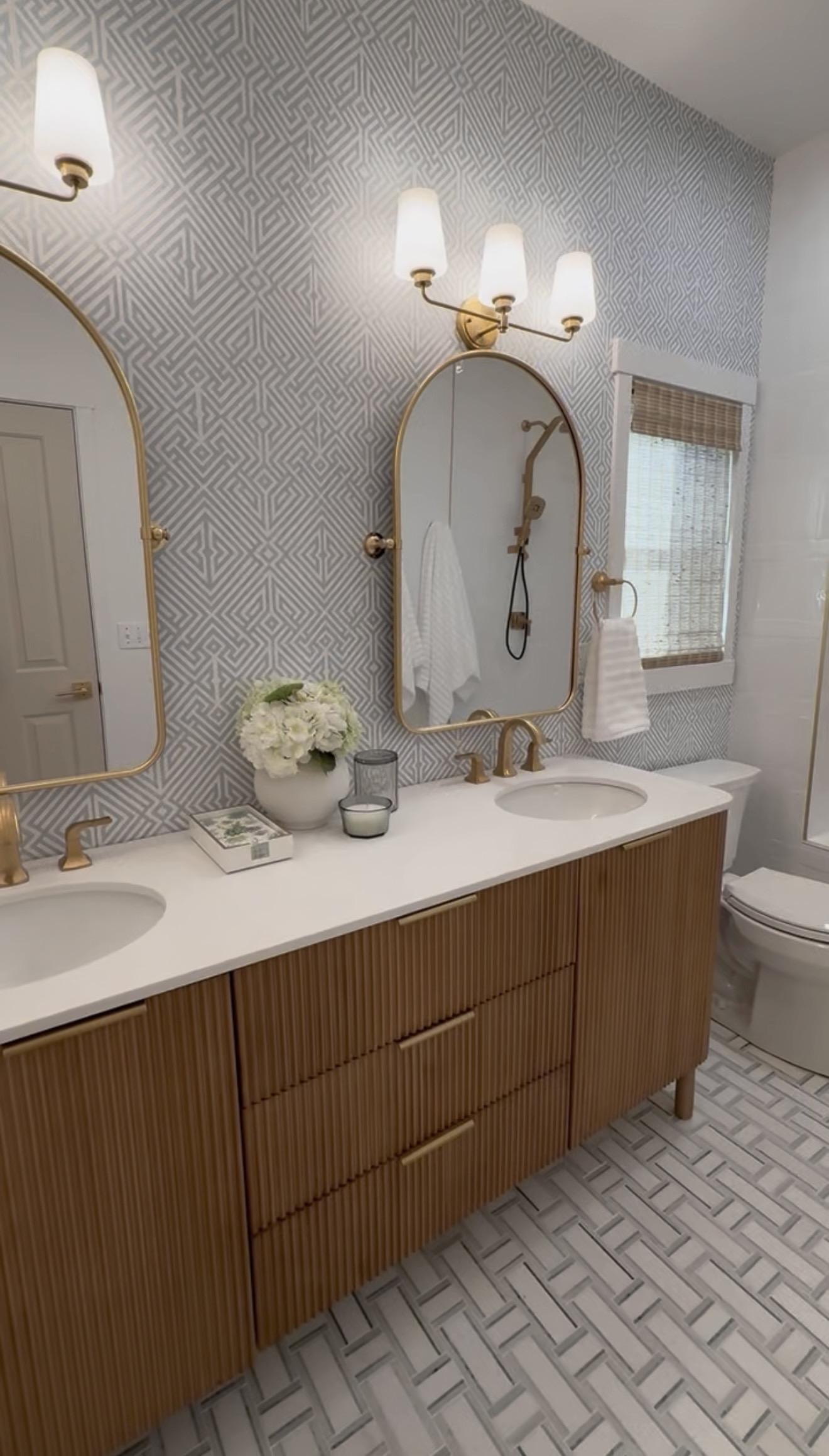 The Primary Bath: warm, spa-like, soft stone and brass