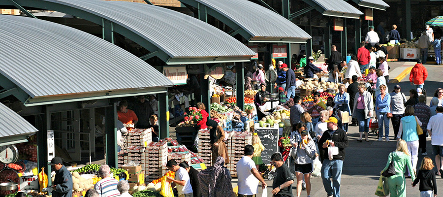 Picture of the Kansas City River Market place. Fresh produce stands line the street with happy market goers and market vendors Picture of the Kansas City River Market place. Fresh produce stands line the street with happy market goers and market vendors