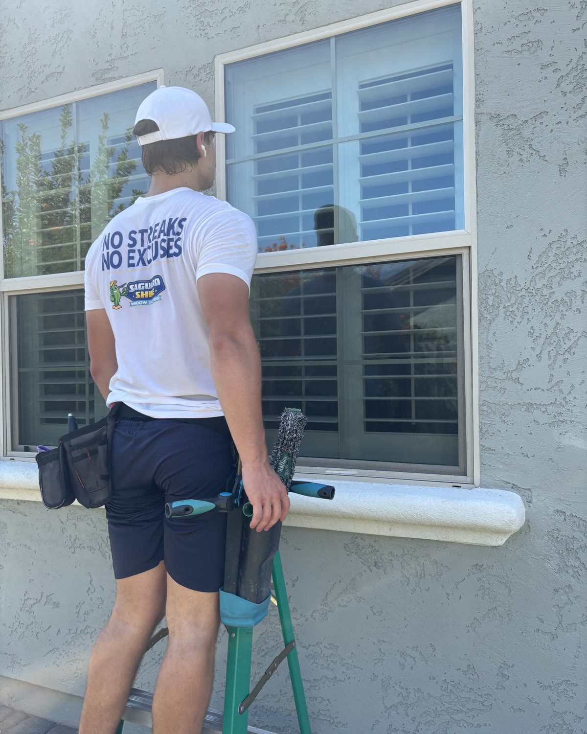 A Saguaro Shine window cleaner working carefully at a residential window