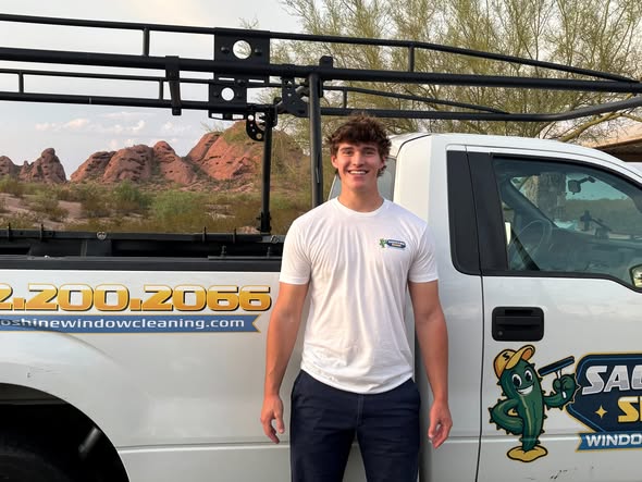 Caden, founder of Saguaro Shine, standing beside the company truck
