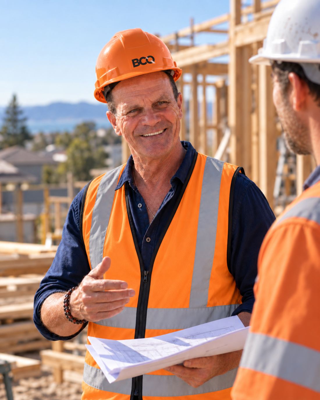John Von Reuth explaining a qualification pathway to a tradesperson while holding building plans on site