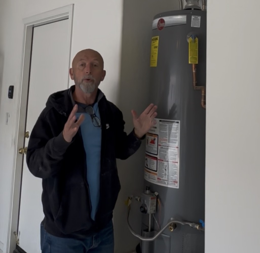 Inspector on a rooftop reviewing HVAC equipment during a top-to-bottom walkthrough
