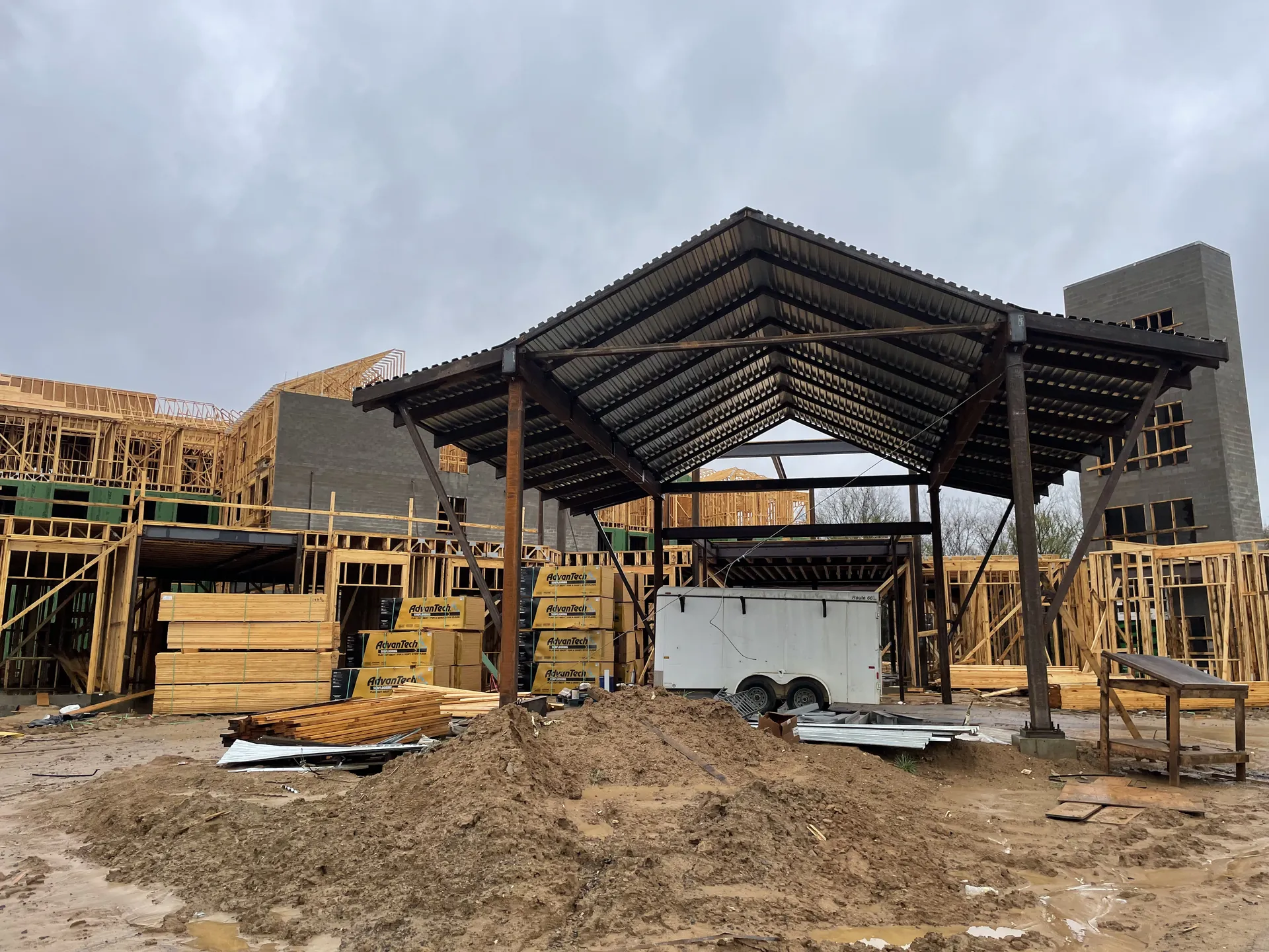 Structural steel canopy framing over a multifamily project, load path visible from roof beam to column base