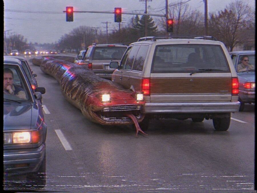 A snake that is also a red Pontiac, waiting at a stoplight