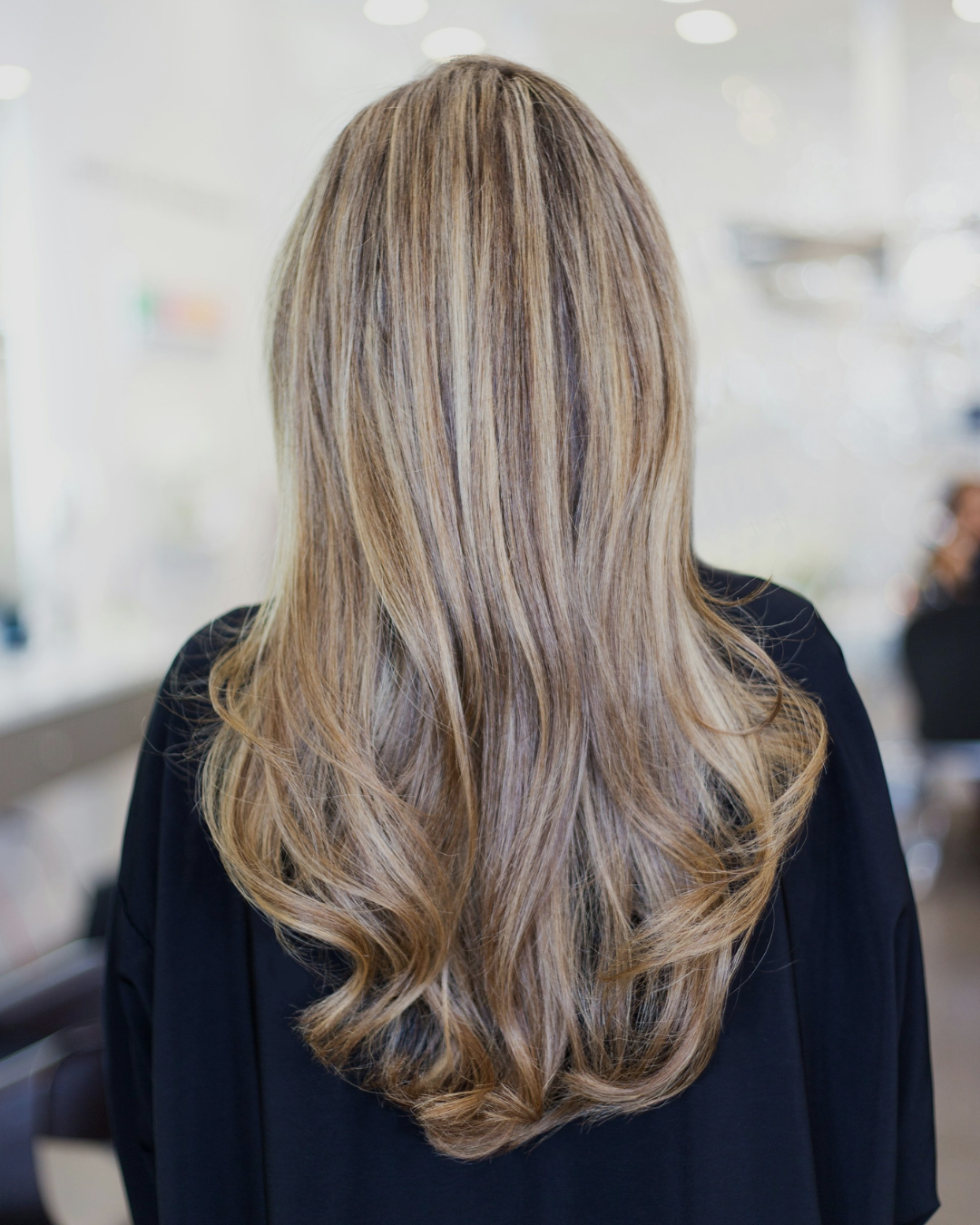 Long blonde hair with dimensional highlights and lowlights showing professional color work at Charbel Hair Beauty salon in Dubai