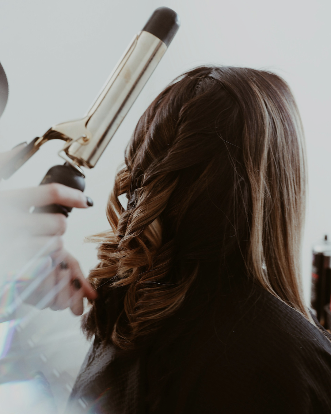 Professional hair cutting and styling with curling iron for perfect hair transformation at Charbel Hair Beauty salon in Dubai