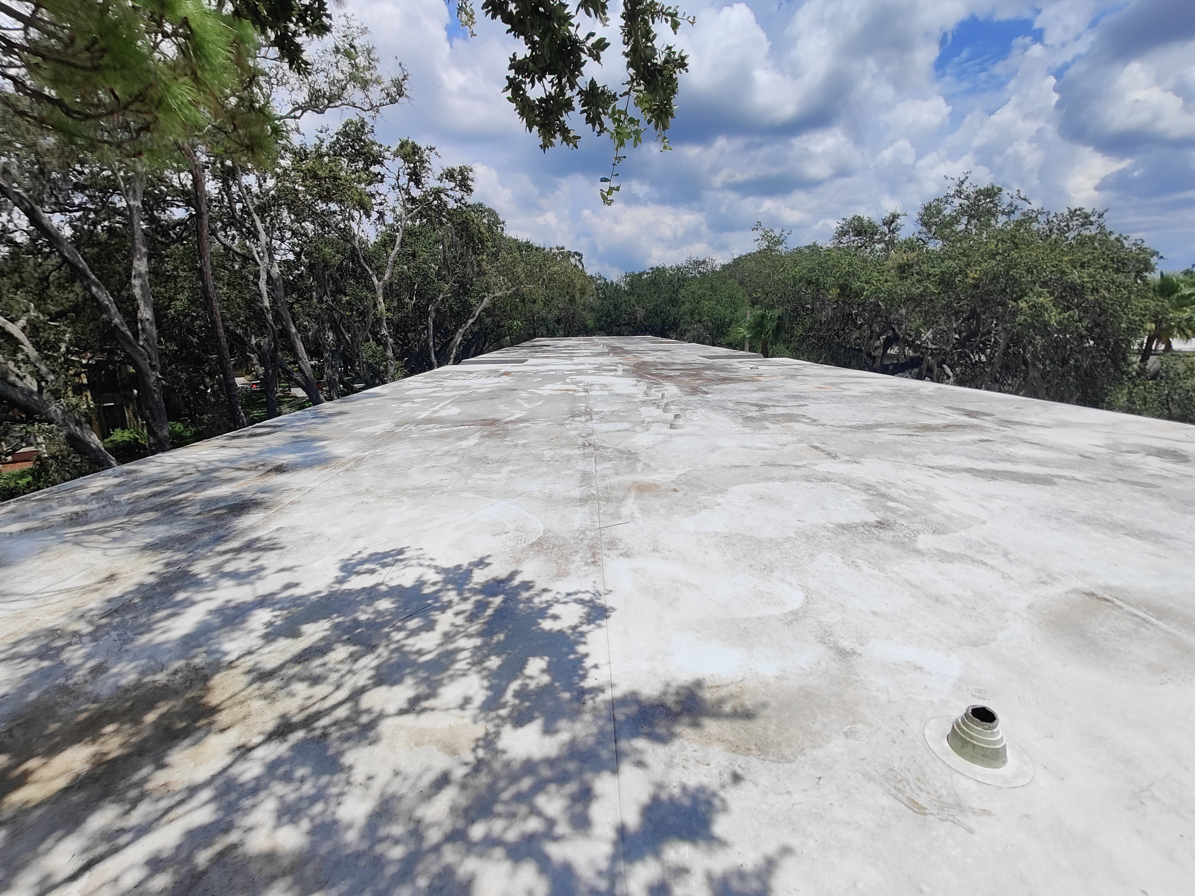 A commercial roof system packed with debris before a cleaning