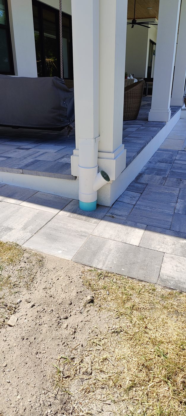 Custom downspout connection by Trufam Drainage tied through pavers into a six inch underground drainage line in Tampa Bay