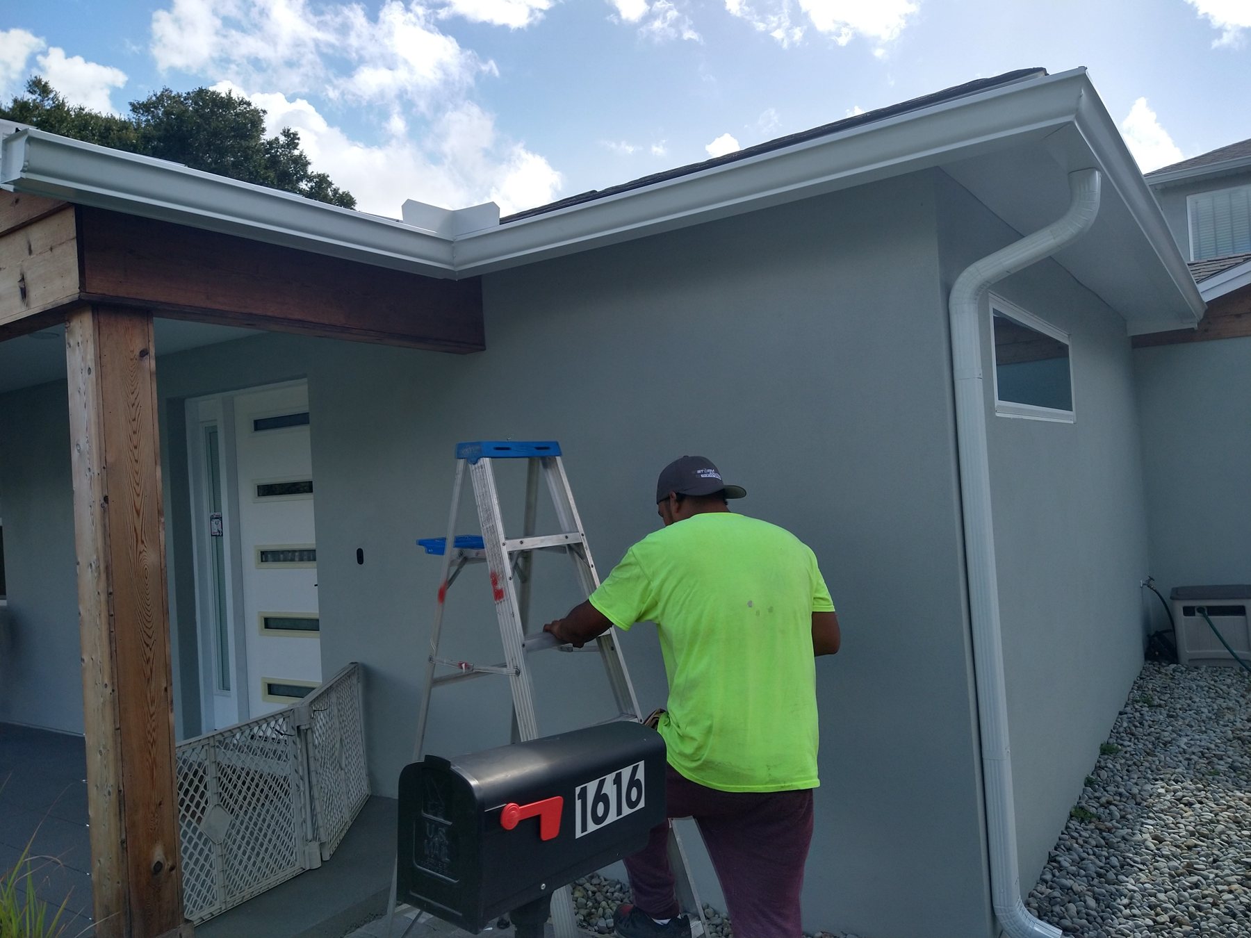 Trufam crew member fitting a gutter and downspout by hand on a Tampa Bay home