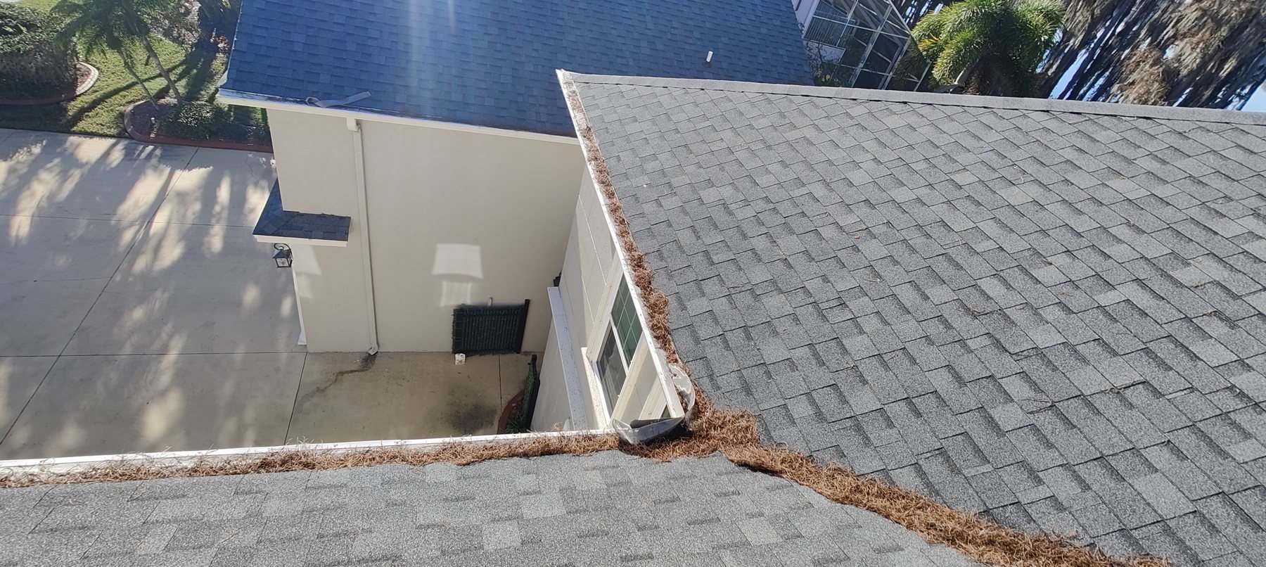 Cheap plastic gutter screen with the mesh blown out in sections and leaves building up on top