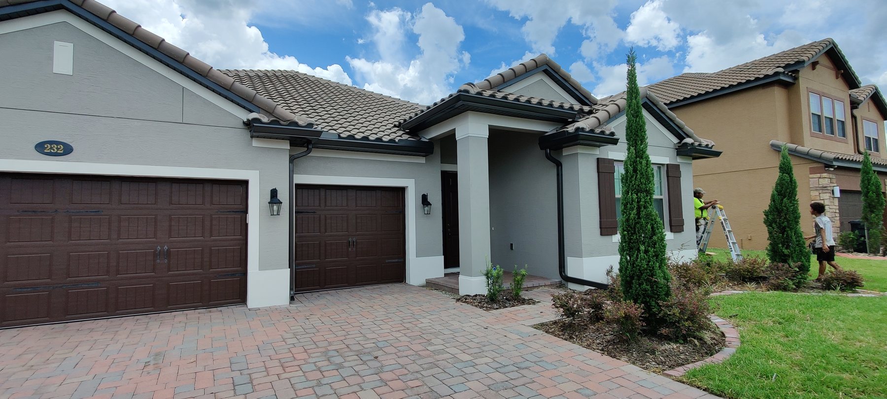 Single-family Tampa Bay home with a tile roof and paver driveway, gutters and guards by Trufam Drainage