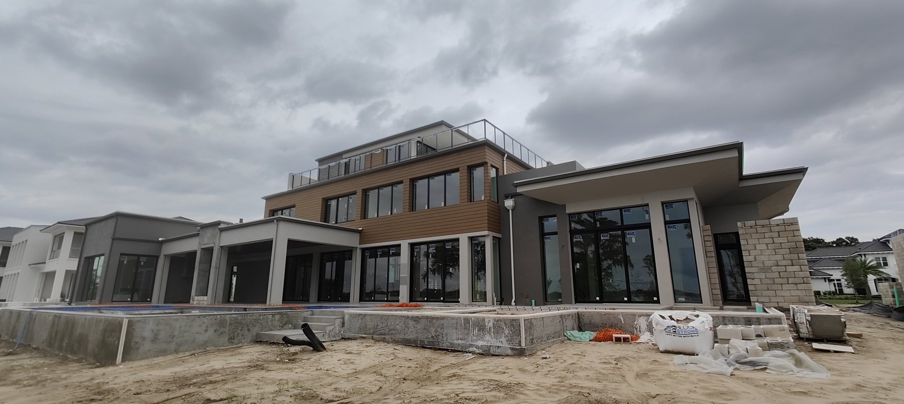 Large modern custom home under construction in Tampa Bay, gutters by Trufam Drainage