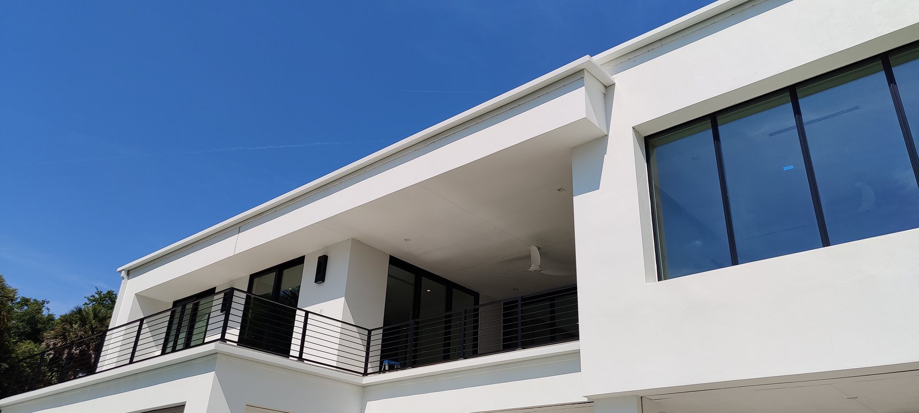 White modern two-story Tampa Bay home with clean Trufam seamless gutter lines along the eaves