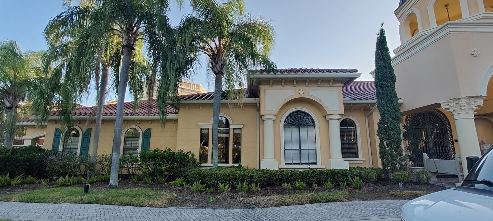 A Tampa Bay Mediterranean home with a tile roof and seamless gutters sized to handle fast runoff