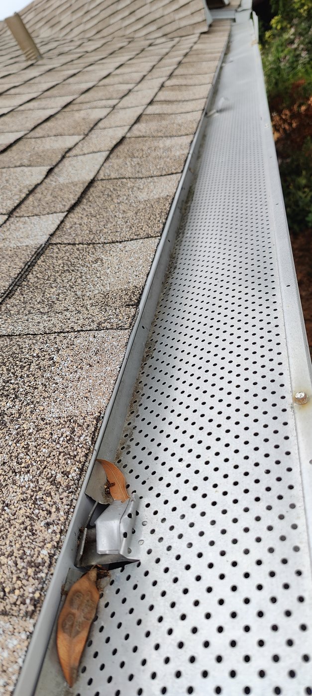 A perforated aluminum gutter guard installed on a Tampa Bay home to keep leaves and debris out