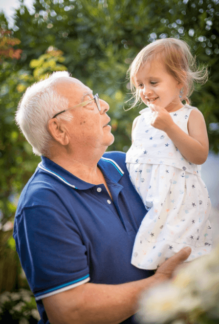 A grandfather looking at his granddaughter through glasses frames and lenses bought at Aspen Eye Care