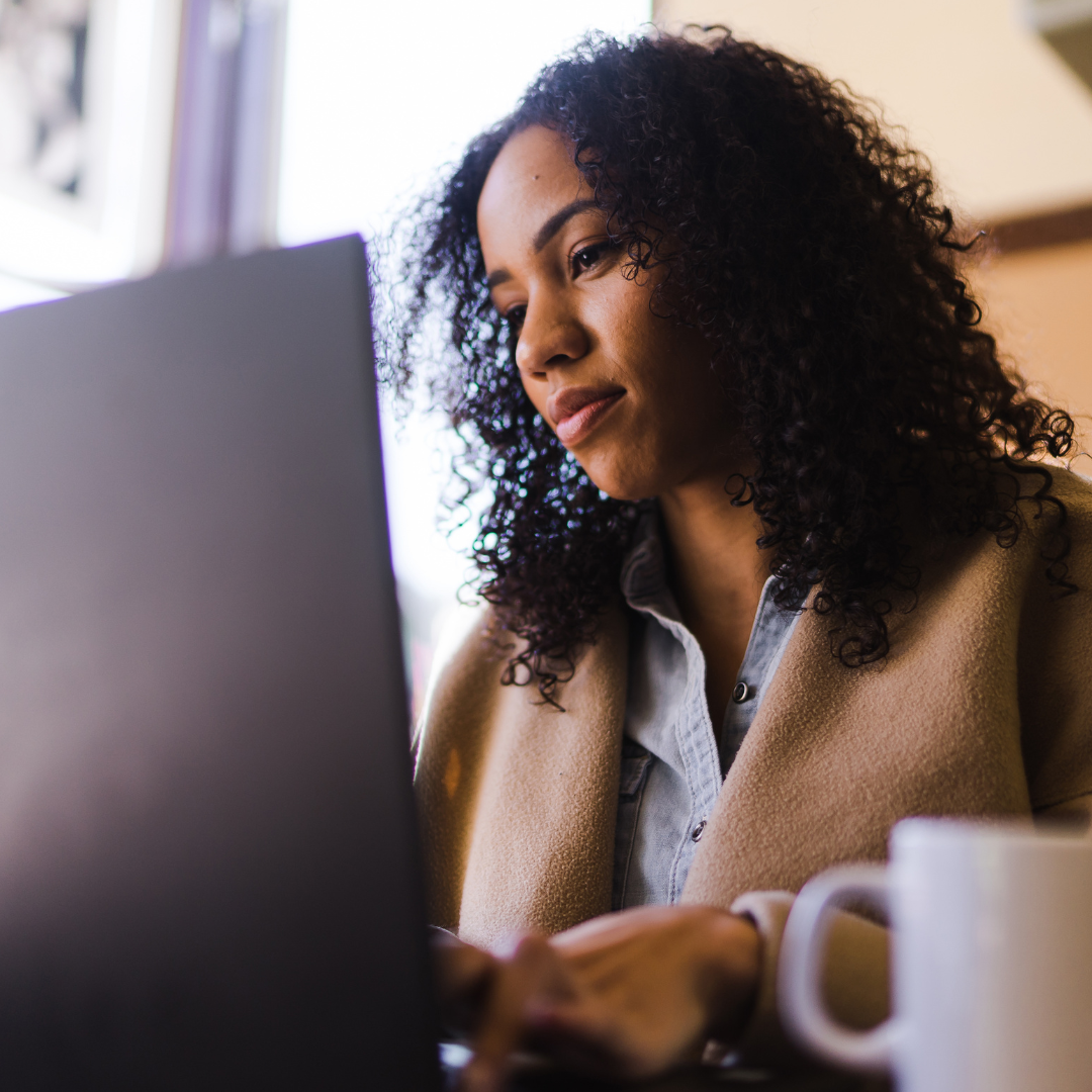 Persona latina profesional trabajando desde casa con su computadora, en un ambiente moderno y luminoso