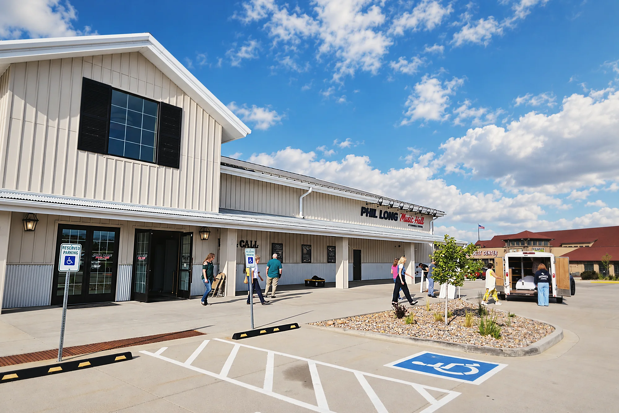 The front of Phil Long Music Hall, with a ground-level entrance and reserved accessible parking by the doors.