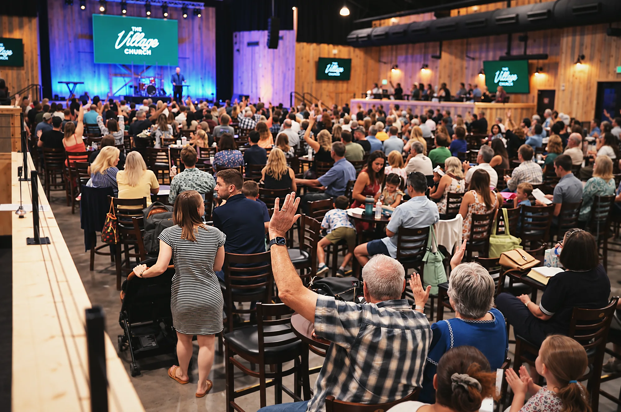 The Village Church gathered at tables inside Phil Long Music Hall, facing the stage.