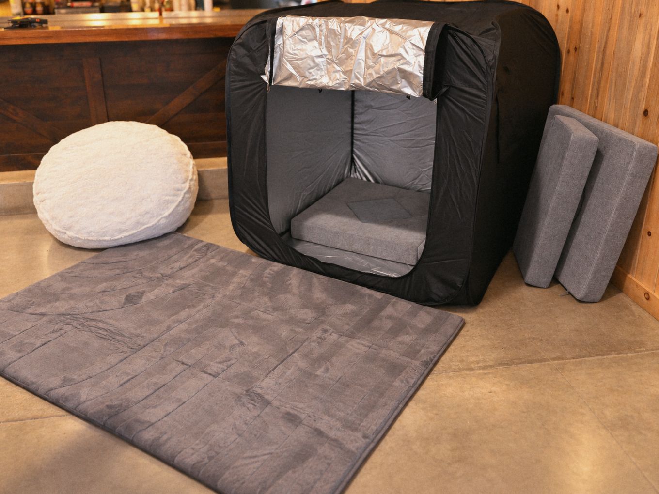 A quiet calm space with a sensory tent, floor mat, cushions, and a soft seat