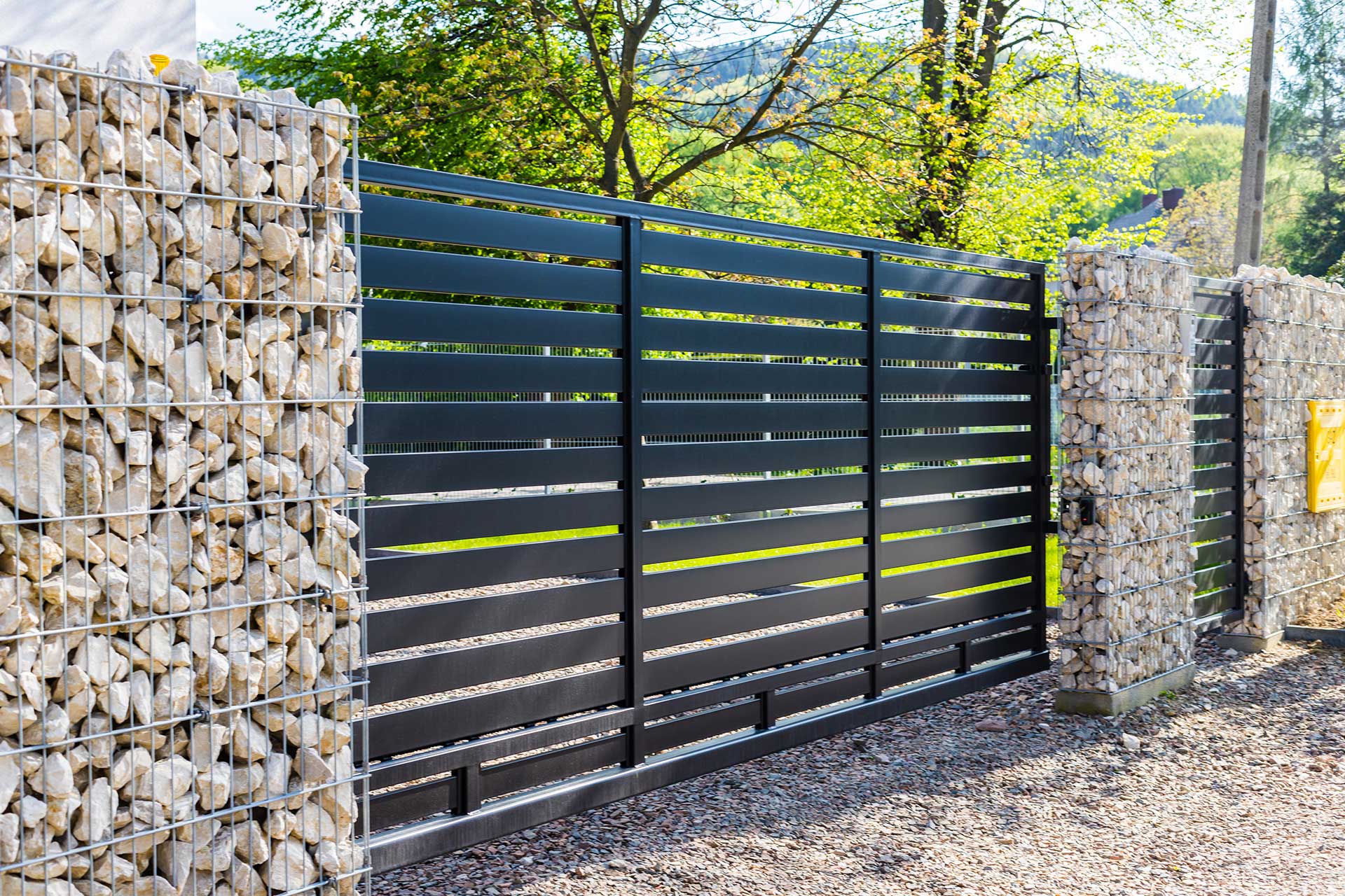 horizontal metal fence with with stone walls