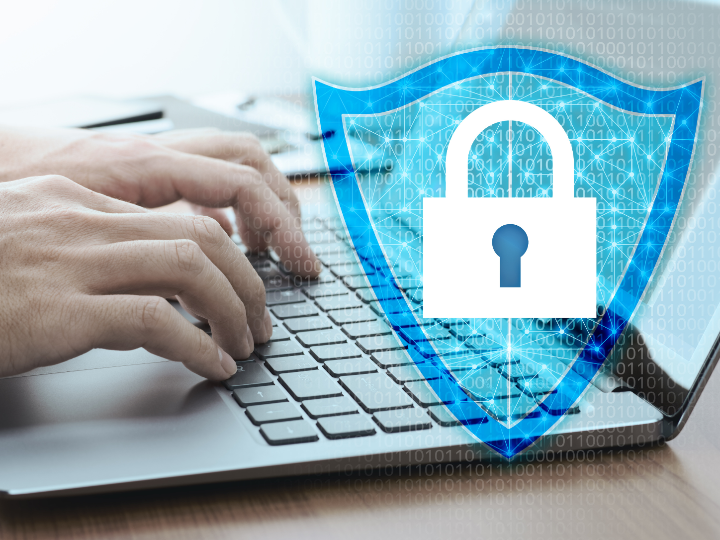 Close-up of a businessman's hands typing on a laptop keyboard, with a glowing blue digital shield and padlock icon overlaid on the screen, surrounded by binary code and network connection lines — representing network security and internet data protection.