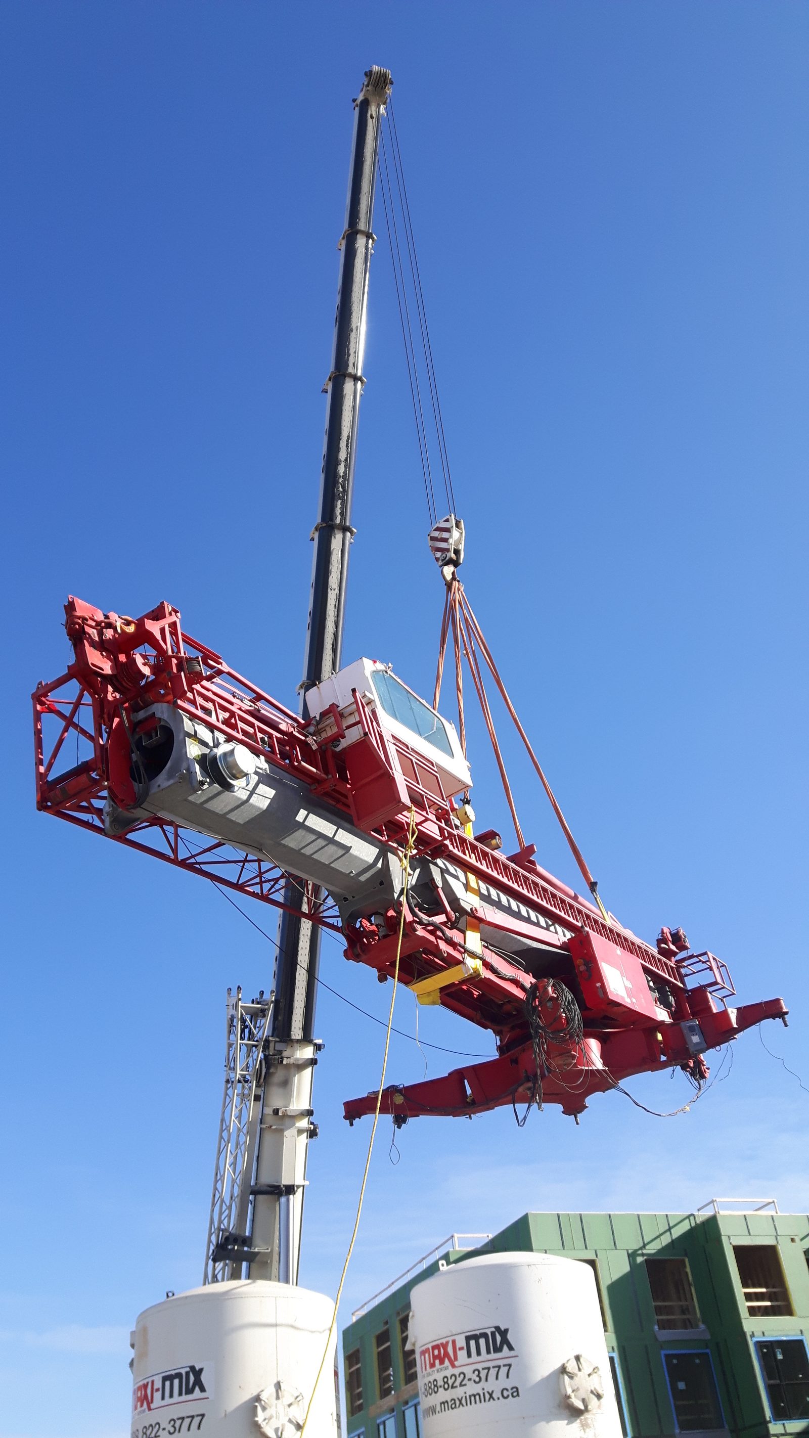 Mobile crane lifting a red tower crane into position at a Toronto construction site