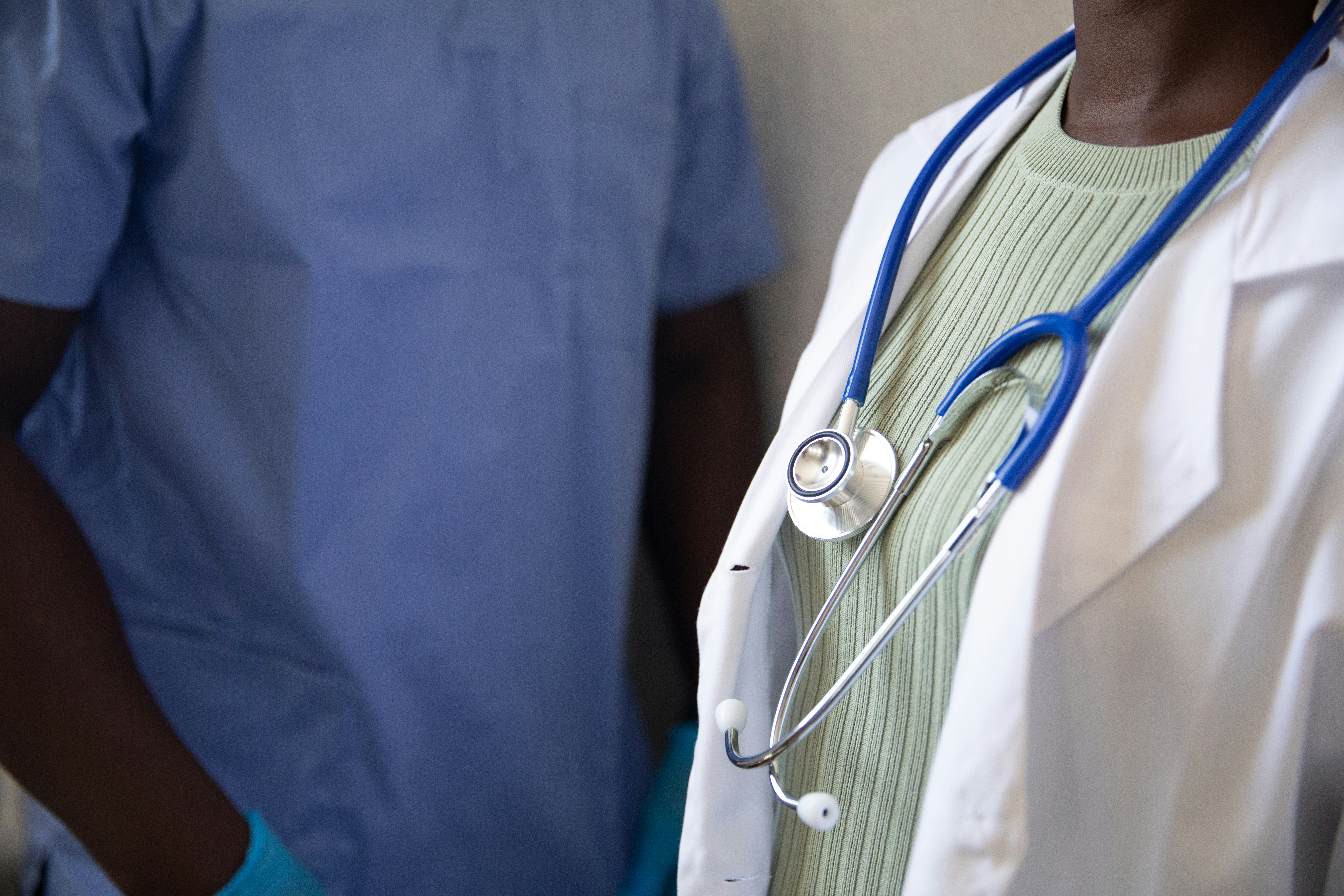 Physician in a white coat using a tablet in an exam room — authentic clinical use of a physician-designed EMR Physician in a white coat using a tablet in an exam room — authentic clinical use of a physician-designed EMR