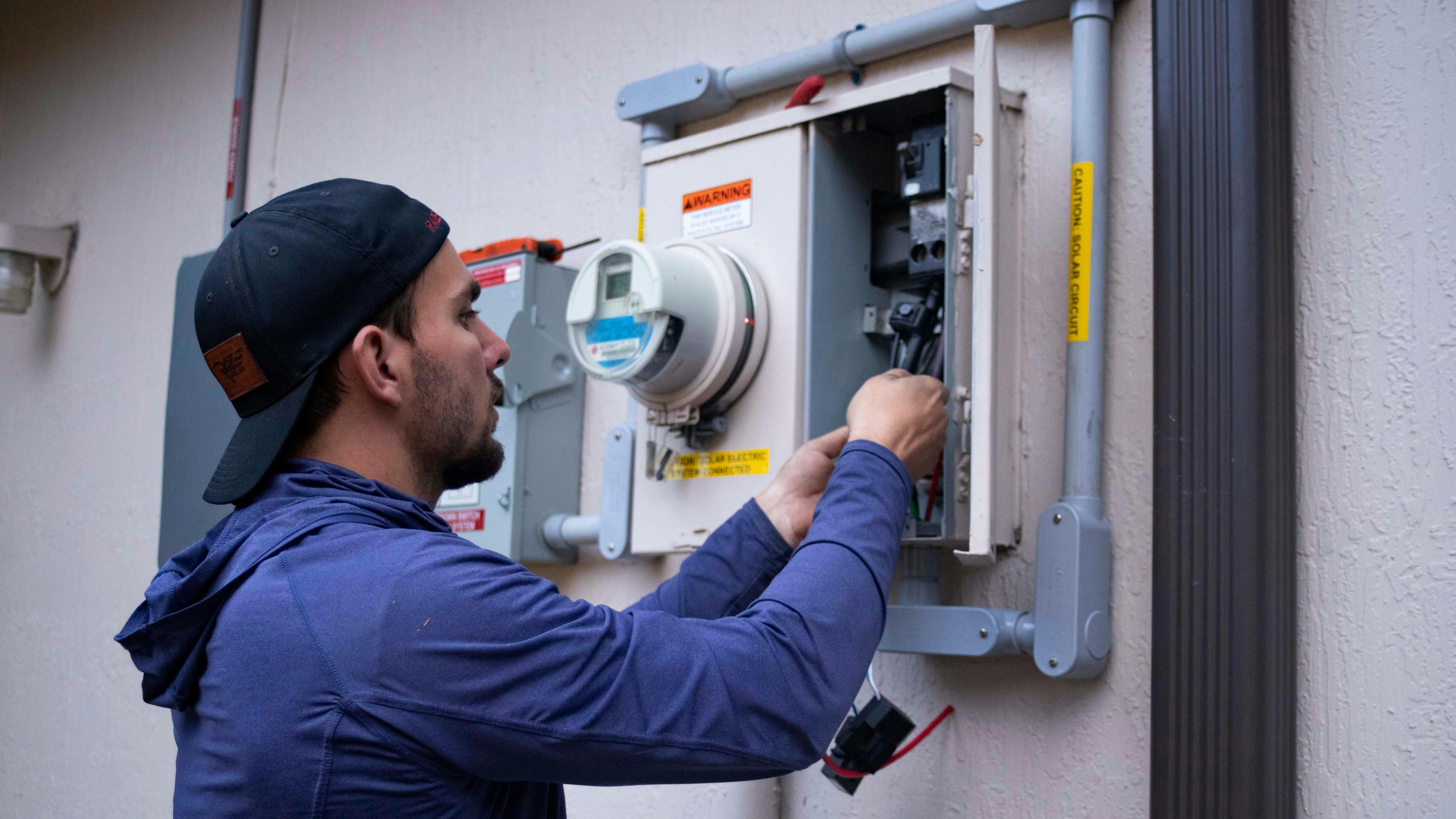 Electrician working on electrical panel — home services business that relies on calls and bookings