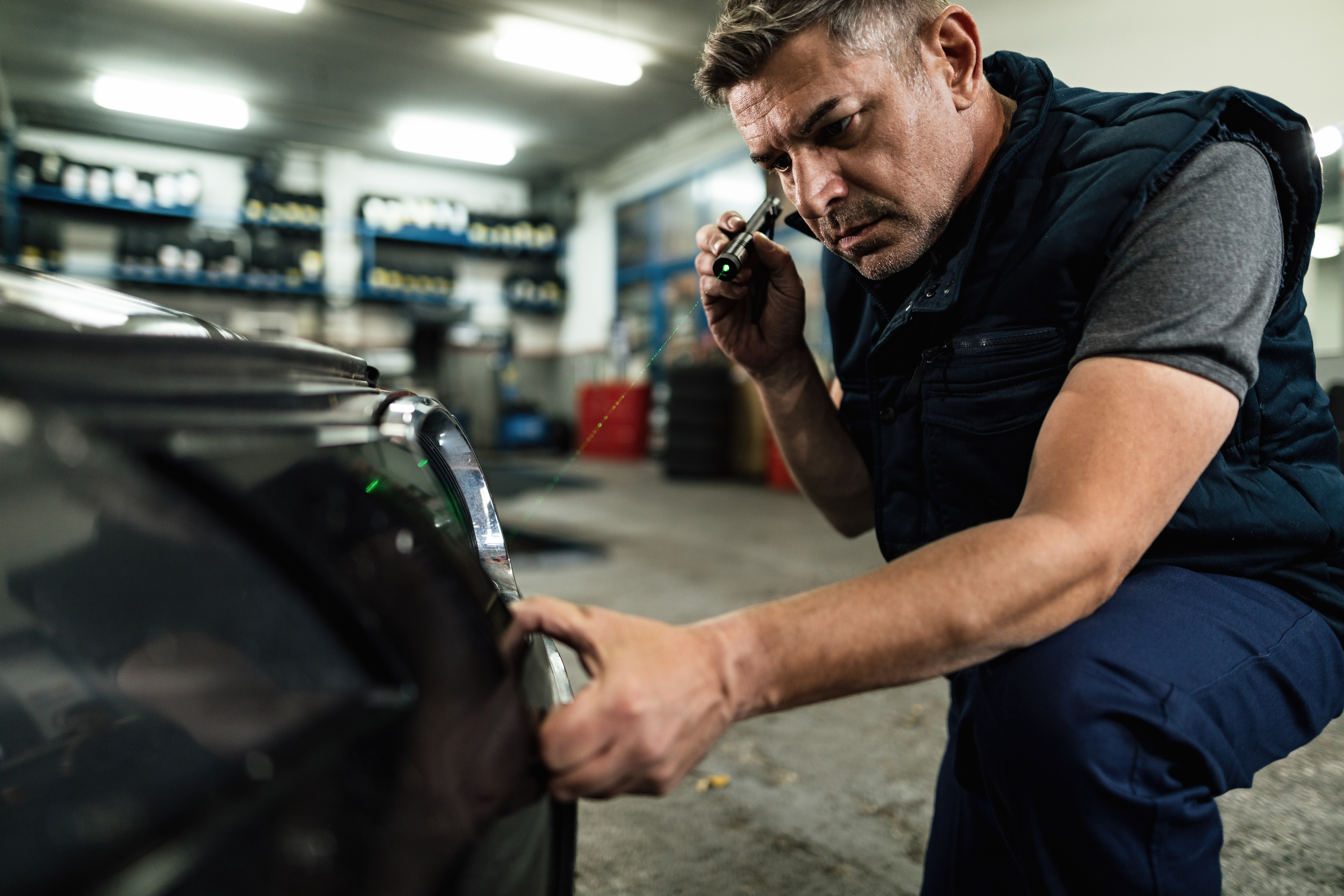 Auto mechanic examining car in repair shop — automotive business relying on fast response and appointment booking
